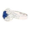 Natural 1.14 Carat Oval Cut Blue Sapphire with Round & Baguette Cut Diamonds in a Swirled 18K White Gold Ring Setting